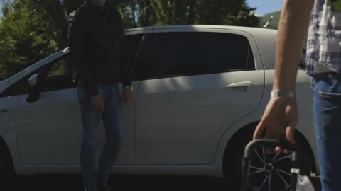 A young boy with a summer hat and suitcase meets and greets his friend, Covid Stock Footage 155249008