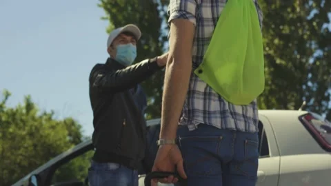 A young boy with a summer hat and suitcase meets and greets his friend, Covid Stock Footage 155249014