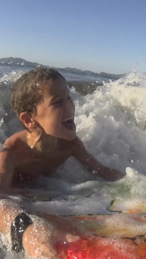 Young Boy surfing jumping waves Body Board at the beach. Vertical, Social Media Stock-Footage 121291023