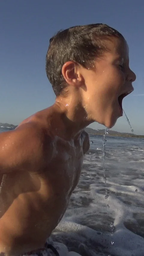 Young Boy surfing jumping waves Body Board at the beach. Vertical, Social Media Stock Footage 121291157