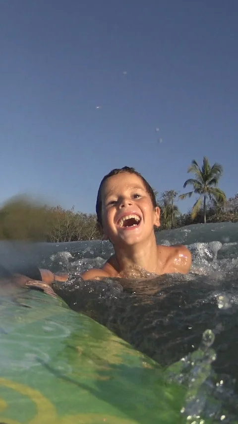 Young Boy surfing jumping waves Body Board at the beach. Vertical, Social Media Stock Footage 121620031