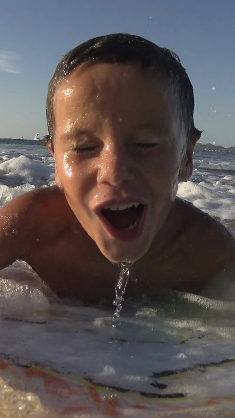 Young Boy surfing jumping waves Body Board at the beach. Vertical, Social Media Stock Footage 121620050