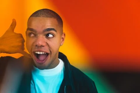 Young boy with a surprised face doing phone gesture with his hand and fingers Stock Photos