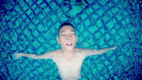 Young Boy Swimming Joyfully in Pool Water Stock Footage 314901715