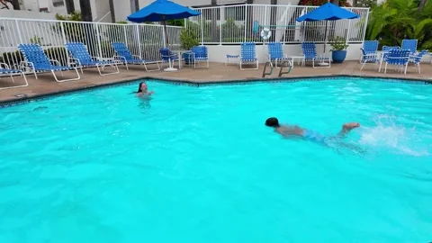 Young boy swimming in pool during a sunny day in San Diego, California at a Stock Footage 337553631