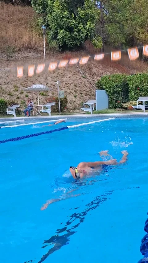 Young boy swimming in a pool – lateral panning shot right to left Stock Footage 312343714