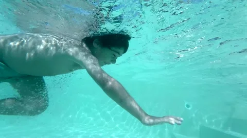 Young boy swimming underwater in a pool Stock Footage 339649783