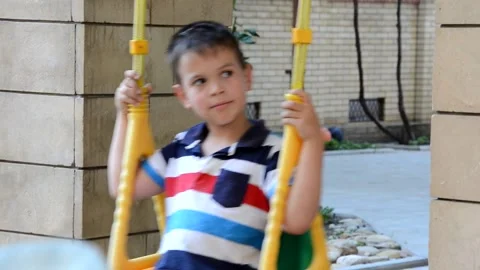 A young boy is swinging set in a park. The small child is having fun 库存影片 151151754