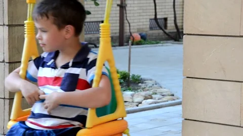 A young boy is swinging set in a park. The small child is having fun 库存影片 151151796