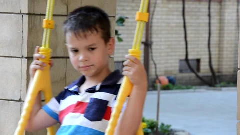 A young boy is swinging set in a park. The small child is having fun Stock Footage 151151830