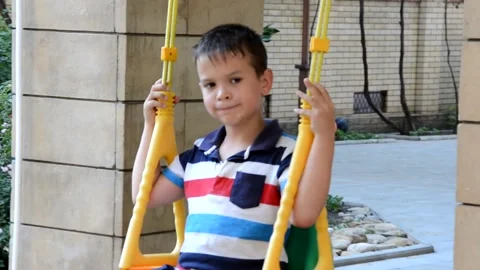 A young boy is swinging set in a park. The small child is having fun 库存影片 151151842