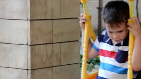 A young boy is swinging set in a park. The small child is having fun 库存影片 151151849