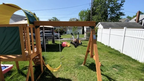 A young boy swinging on a swing set Stock-Footage 129465212