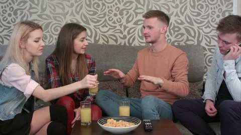 Young boy talking on cellphone and his friends talking next to him, sitting on Vidéo 73473607