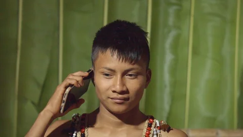 Young boy talking on mobile phone pretending to be in a real conversation in Video stock 113180756