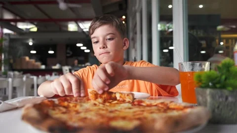Young boy tear off a slice of freshly baked hot four cheeses pizza and going to Stock Footage 279127992