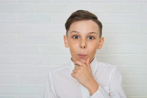 Young boy thinkin on white background looking at camera Stock Photos