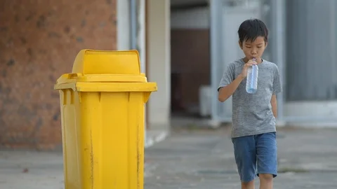 Young boy throw a plastic bottle Stock Footage 106525043