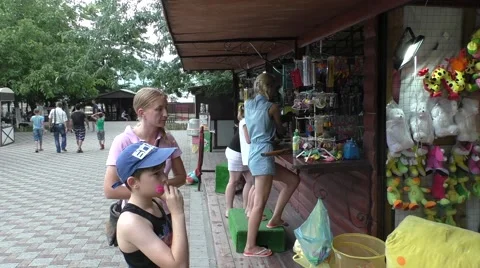 Young Boy is Throwing Darts in Attraction Park, on Background People Are Stock Footage 64930023