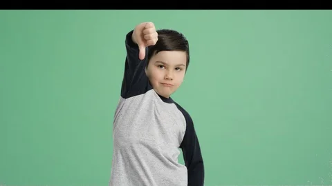 Young  boy thumbs-down to the camera - Alpha Channel, Green Screen Stock Footage 129346833