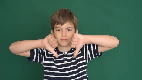 Young boy with thumbs down on the green screen Stock Footage 118378488