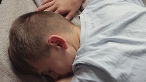Young boy tossing and turning in bed, frequently shifting positions through.. Stock Footage 294549232