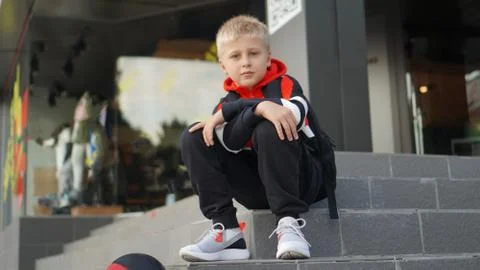 Young boy in training suit posing with basketball in front of store. 写真素材