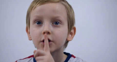 Young boy trying to attract attention surreptitiously, gesticulating his face Stock Footage 125526898