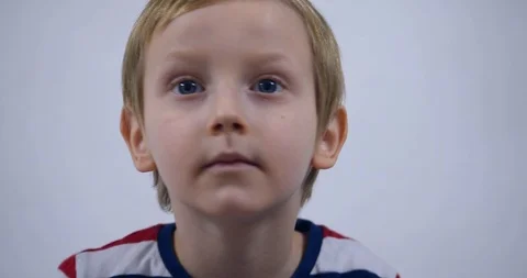 Young boy trying to attract attention surreptitiously, gesticulating his face Stock Footage 125526973