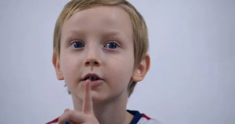 Young boy trying to attract attention surreptitiously, gesticulating his face Stock Footage 125526978