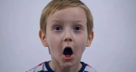 Young boy trying to attract attention surreptitiously, gesticulating his face Stock Footage 125527014