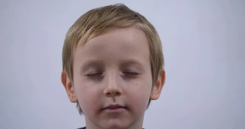 Young boy trying to attract attention surreptitiously, gesticulating his face Stock Footage 125527019