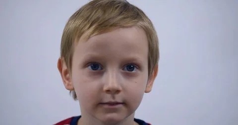 Young boy trying to attract attention surreptitiously, gesticulating his face Stock Footage 125527086