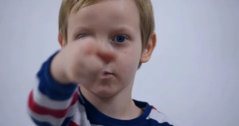 Young boy trying to attract attention surreptitiously, gesticulating his face Stock Footage 125527099