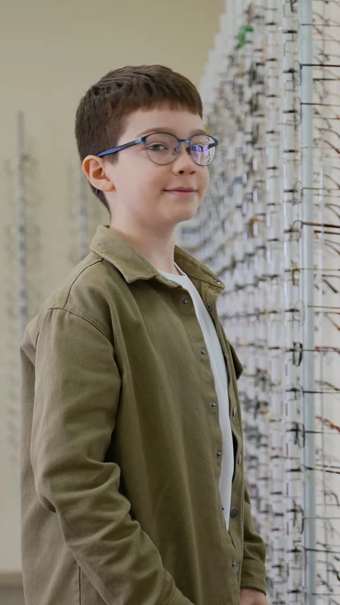 Young boy trying eyeglasses in optical store Stock Footage 310812200