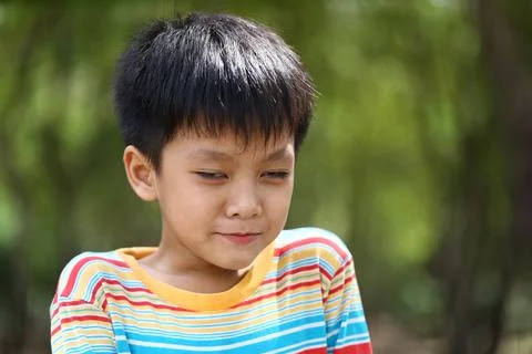 Young Boy with Uncertain Expression in Nature Setting Stock Photos