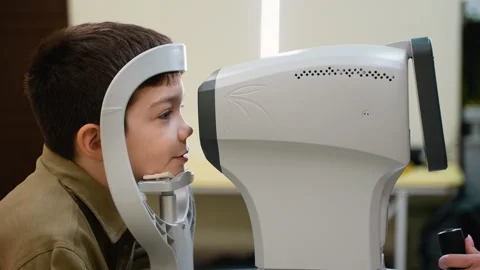 Young boy undergoing comprehensive eye examination using modern equipment Stock Footage 310805729