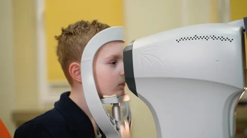 Young boy undergoing comprehensive eye exam with modern equipment Stock Footage 310805883
