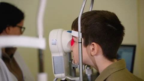 Young boy undergoing comprehensive eye examination by optometrist Stock Footage 310809287