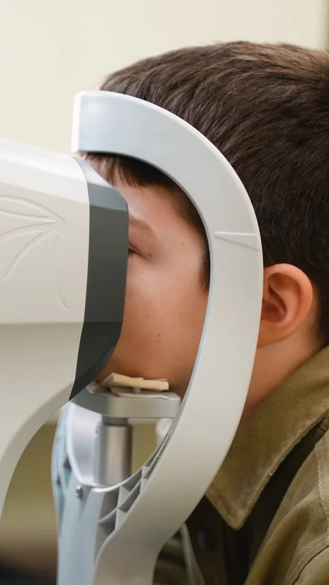 Young boy undergoing comprehensive eye exam with modern equipment Stock Footage 310811922