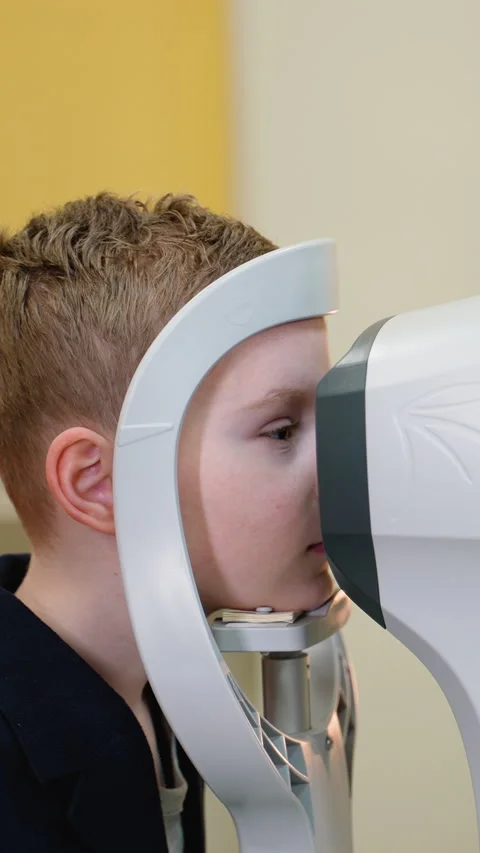 Young boy undergoing comprehensive eye exam using modern equipment Stock Footage 310811984