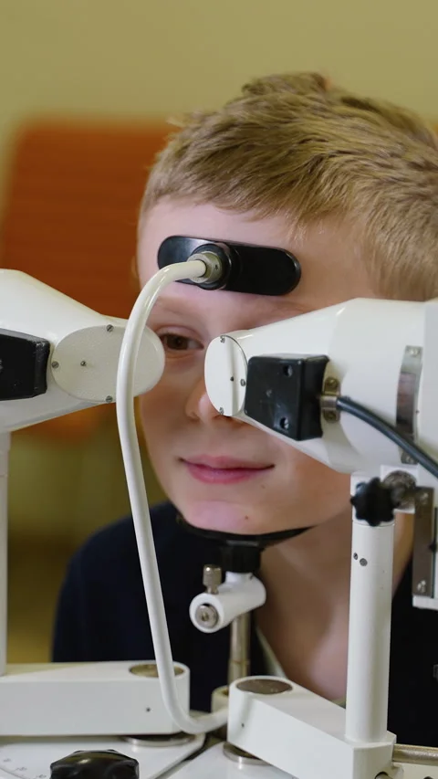 Young boy undergoing comprehensive eye examination at modern clinic Stock Footage 310812013