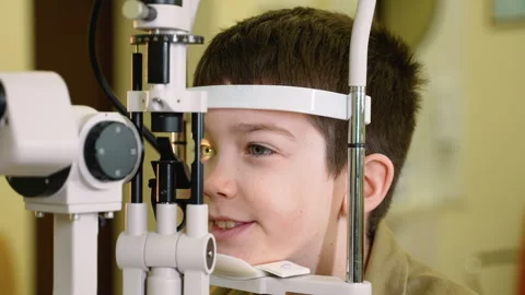 Young boy undergoing eye examination with slit lamp Stock Footage 310808214
