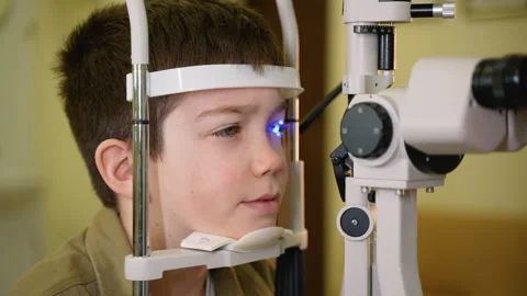 Young boy undergoing eye examination with modern equipment Stock Footage 310808667
