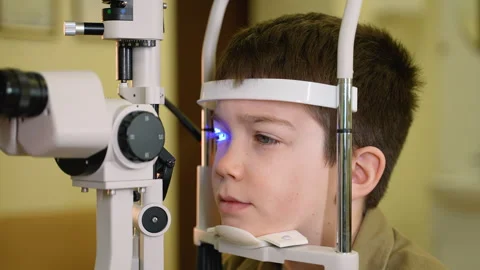 Young boy undergoing eye examination with modern equipment Stock Footage 310808716