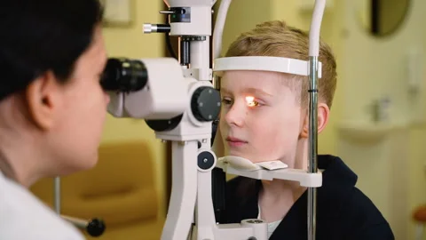 Young boy undergoing eye examination by optometrist Stock Footage 310808824