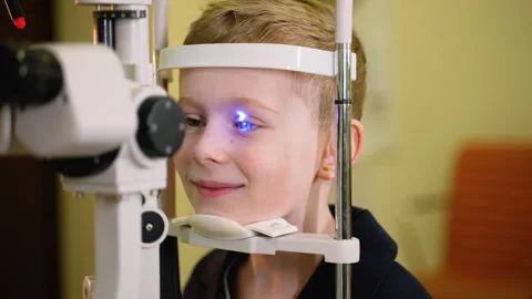 Young boy undergoing eye examination with slit lamp Stock Footage 310808946