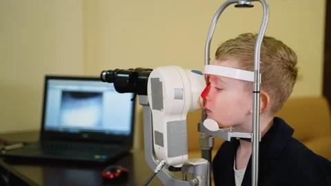 Young boy undergoing eye examination with modern equipment Stock Footage 310809736