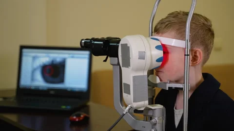 Young boy undergoing eye examination with modern equipment Stock Footage 310809866