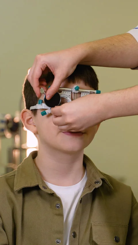Young boy undergoing eye examination with trial frame Video stock 310812113